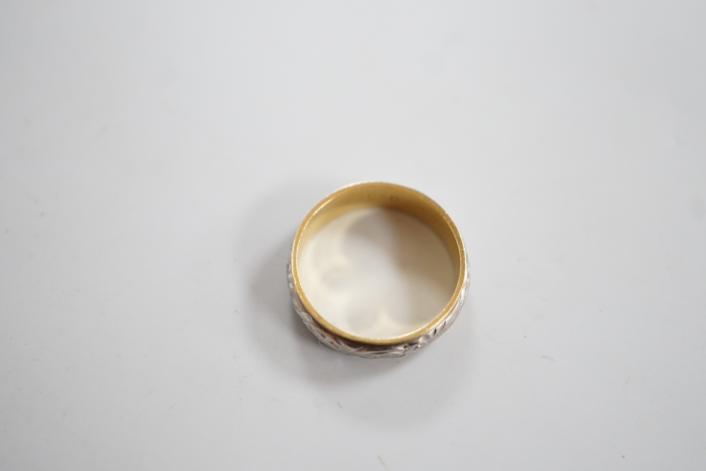 An engraved yellow and white metal band, size L, 3.7 grams.